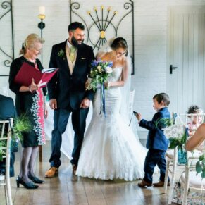 Young pageboy asking how his camera works just as the newlyweds are about to exit their civil ceremony at the Five Arrows Hotel 