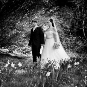 The newlyweds stroll through the trees and towards the summerhouse on this stunning spring day 