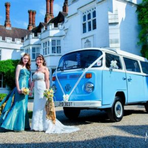 The bride and bridesmaid pose with the VW Camper at this Danesfield House fun summer wedding
