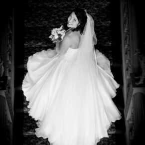 The bride on the Jacobean staircase dramatically captured from above in black and white at her Hartwell House wedding 