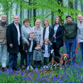 This larger group pose was captured in a colourful bluebell woods in the Buckinghamshire countryside during a rain soaked family photography portraits session 