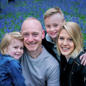 Small family group pose captured in a colourful and magical bluebell woodland in the Buckinghamshire countryside during this portraits photography session