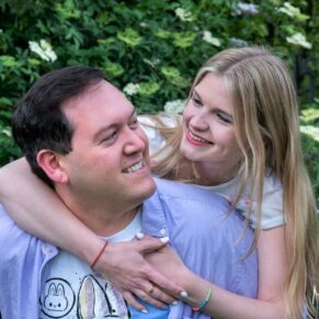 A newly engaged couple perform a piggyback in front of the camera during their Buckinghamshire photography photo-shoot portraits 