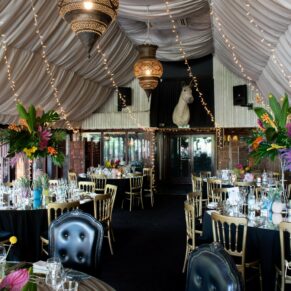The Dining Room interiors decked out with the wedding couple's exotic tropical themed flowers and table centre pieces at The Crazy Bear Hotel in Stadhampton