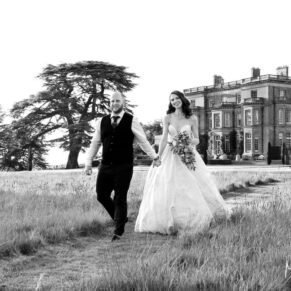 Black and white wedding photography shot of the newlyweds taking a stroll through the grounds of Hedsor House in Buckinghamshire