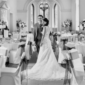 Buckinghamshire Black and White Wedding Photography - the newlweds pose for the camera inside the dining room at Clearwell Castle