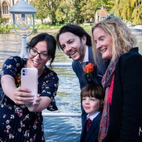 Candid and reportage Buckinghamshire wedding photographer - three guests pose for a fun selfie beside the River Thames 