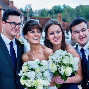 The bride with her children looking away from the camera in the grounds of the Kings Chapel in Old Amersham 