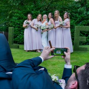 Buckinghamshire Marquee Wedding Photography - the groom has a great angle in mind for this relaxed pose of the bride with her bridesmaids 
