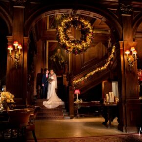 Buckinghamshire Winter Wedding Photography - the newlyweds pose on the staircase for their Cliveden House marriage