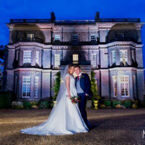 Buckinghamshire Winter Wedding Photography - the bride and groom strike a pose at dusk in front of Hedsor House