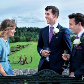 Reportage wedding photography of the couple's sons and daughter with distant views of the Cliveden House gardens from the private terrace