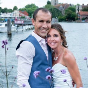 Portrait of the smiling bride and groom on their wedding day with the Marlow River Thames behind them