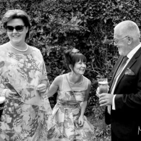 Candid moment captured during the drinks reception at Danesfield House Hotel of three wedding guests giggling away