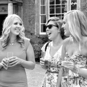 Reportage image of ladies chatting and giggling during this summer wedding drinks reception   
