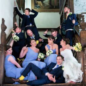 The bridal party strike a pose on the main staircase at Dorton House in Buckinghamshire 