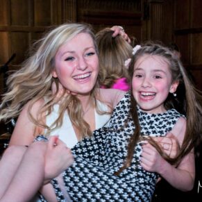Fun wedding capture taken on the dance floor of a lady lifting a young girl in her arms at Dorton House in Buckinghamshire 
