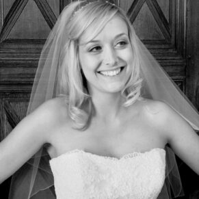 The bride strikes a pose against a wood panelled backdrop at her Dorton House wedding 