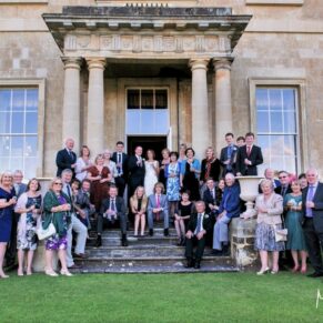 A large formal family group pose on the outdoor steps at Hartwell House Hotel