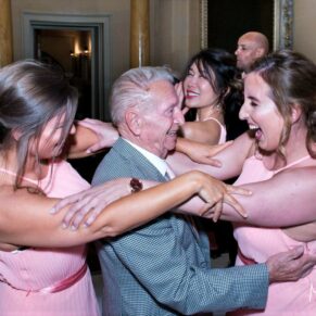 Grandad loving the moment on the dance floor as he's surrounded by the bridesmaids at this Hartwell House wedding