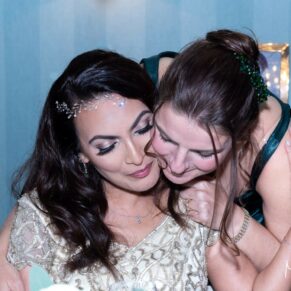 A special moment between the bride and her bridesmaid captured at the top table during this wonderful Hartwell House wedding  