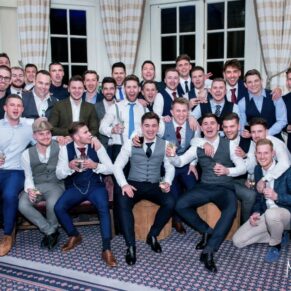 Thirty lively lads casually pose for the camera in the bar of Hedsor House 