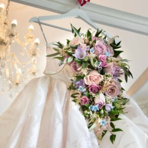 The stunning bouquet together with the bride's highly detailed gown captured hanging from the bed at her Hedsor House wedding 