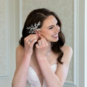 The bride making adjustments to her ear rings in the bridal suite before her wedding ceremony at Hedsor House 