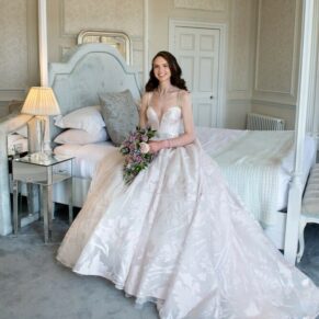 The gorgeous bride elegantly sat on the four poster bed in the wonderful bridal suite at her Hedsor House wedding