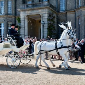 The horse and carriage with its newly married passengers are waved off by the guests at this Hedsor House summer wedding  