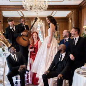 The newlyweds strike a pose with the Function Band in the dining room at their Hedsor House wedding 