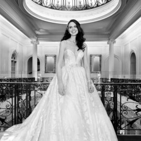 The bride strikes a classic pose for the camera at the top of the historic staircase