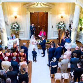 Looking down on the packed wedding ceremony from the balcony in the Great Hall at Hedsor House 