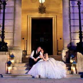 Atmospheric candle lighting for this romantic wedding pose of the newlyweds at the front door entrance to Hedsor House 