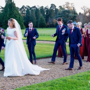 The newlyweds and their bridal party take a relaxed stroll in the gardens at Hedsor House in Buckinghamshire 