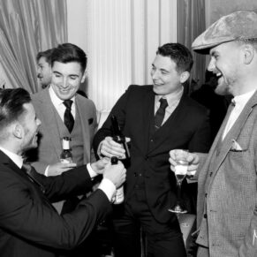 Lively guest banter in the bar at this Hedsor House wedding 