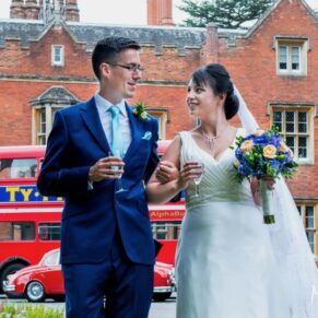 Photography of the newlyweds taking a stroll with their London red bus behind during their Latimer Estate summer wedding 