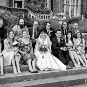Photography of the bride and groom with some friends on the grand outdoor steps of  Latimer Estate on their wedding day  