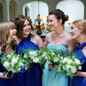 The bridesmaids enjoy a giggle at the top of the stairs just before the marriage ceremony 