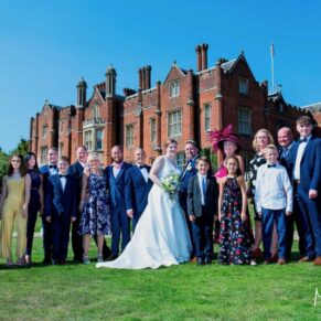 Family group pose with the historic Latimer Estate in the distance for this summer celebration