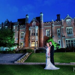 Dramatic floodlit photography of the newlyweds outside the main house at their Latimer Estate wedding 