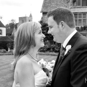 The bride and groom giggle at one another in the gardens at their  Le Manoir Aux Quat Saisons wedding