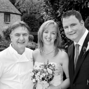 Raymond Blanc joins the bride and groom for a photograph in the gardens of Le Manoir Aux Quat Saisons  