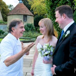 The newly married couple meet Raymond Blanc in the gardens at their Le Manoir Aux Quat Saisons wedding 
