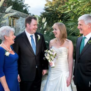 An informal moment between the newlyweds and their parents during the drinks reception at this Le Manoir Aux Quat Saisons wedding 