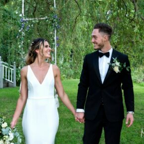The couple take a stroll through the lush summery gardens on their special day