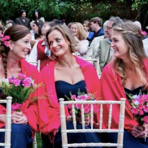 Micklefield Hall Wedding Photography - the bridesmaids captured giggling in the front row of the outdoor ceremony
