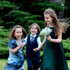 Three children running through the gardens giggling during this fun packed day