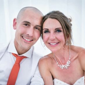Monkton Barn Wedding Photography - the newlyweds pose for the camera in the marquee