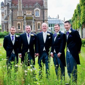 Odney Club Wedding Photography - formal pose of the lads shot through the wild flowers